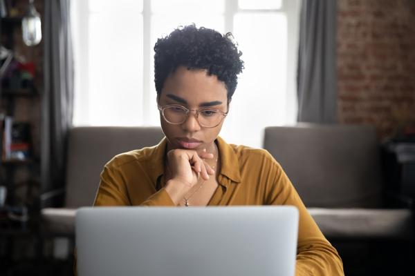 African Woman Glasses Sit Desk Staring Laptop Screen Learn New Software Makes Assignment Working Looks Concentrated Search Solution Ideas Business Challenge Thinks Task Concept