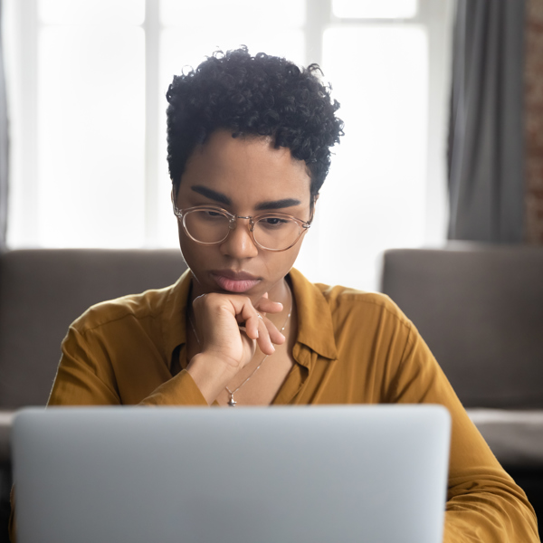 African Woman Glasses Sit Desk Staring Laptop Screen Learn New Software Makes Assignment Working Looks Concentrated Search Solution Ideas Business Challenge Thinks Task Concept