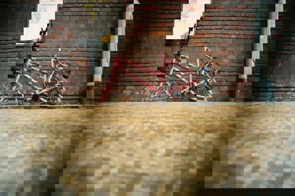 A broken abandoned bicycle with no wheels