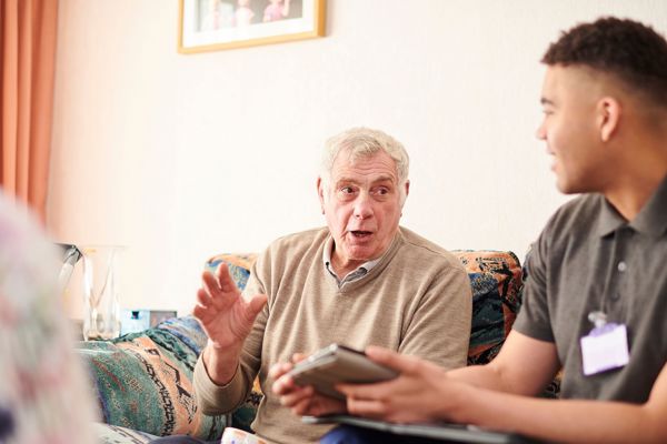 Man And Colleague Sat On Sofa Talking