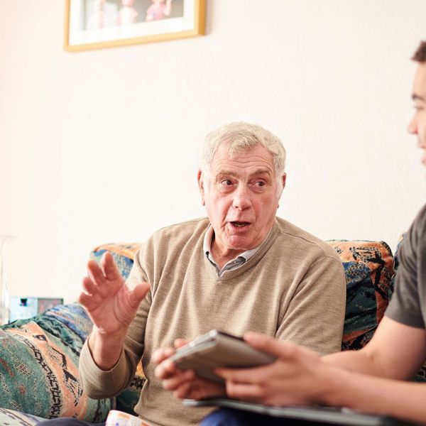 Man And Colleague Sat On Sofa Talking